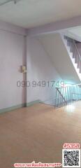 Interior view of a staircase landing with pink walls and tiled flooring