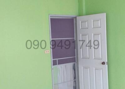 Empty bedroom with green walls and white door