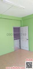Empty bedroom with green walls and white door