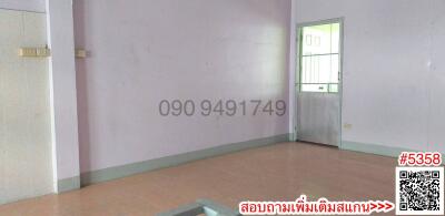 Empty interior room with tiled flooring and a green door