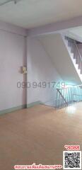 Interior view of a building showcasing staircase and tiled flooring