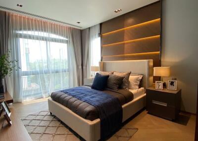 Modern bedroom with a large bed, stylish lighting, and a view of the outdoors