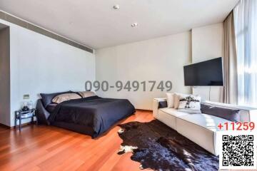 Modern bedroom with king-sized bed, hardwood floors, and natural light