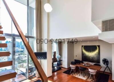 Spacious and modern living room with city view, staircase and beautiful lighting