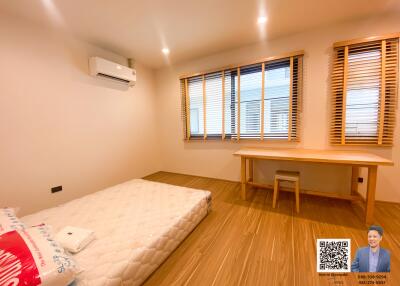 Spacious bedroom with wooden floor and large windows