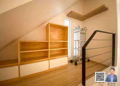 Wooden staircase with bookshelf and railing in a modern home