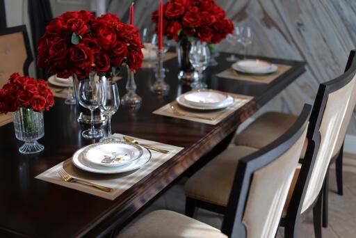 Elegant dining room with red floral centerpieces and modern table setting