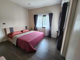 Cozy bedroom with a large bed and hardwood flooring