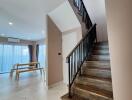 Interior view of a modern home featuring a staircase and a glimpse into the dining area