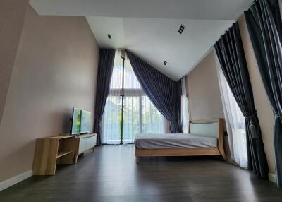 Modern bedroom with large windows and dark wood flooring