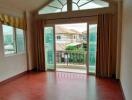 Spacious living room with balcony access and scenic neighborhood view