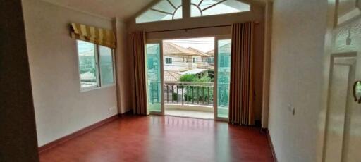 Spacious living room with balcony access and scenic neighborhood view