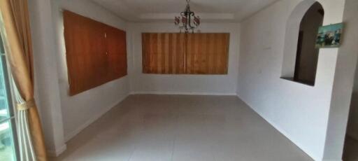 Spacious unfurnished living room with large windows and tiled flooring