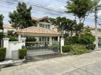 Elegant two-story house with a tiled roof and fenced front yard