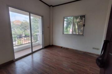 Spacious bedroom with hardwood floors and balcony access