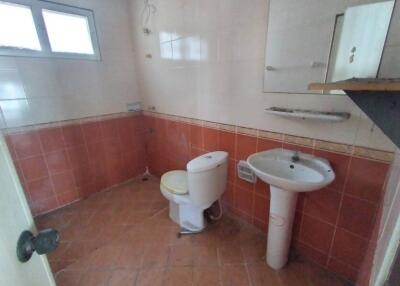 Small bathroom with basic facilities including a toilet and sink, in need of renovation
