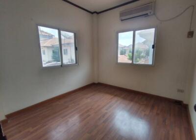 Spacious and well-lit bedroom with hardwood flooring and air conditioning