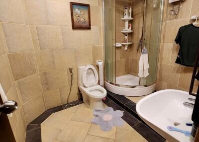 Spacious tiled bathroom with shower cabin and bathtub