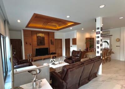 Spacious living room with modern furniture, decorated ceiling, and tiled flooring