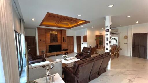 Spacious living room with modern furniture, decorated ceiling, and tiled flooring