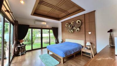 Spacious bedroom with wooden furniture and garden view