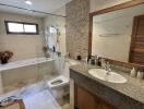 Spacious bathroom with modern amenities and natural stone accent wall