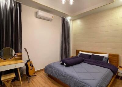 Cozy bedroom with wooden flooring and modern lighting