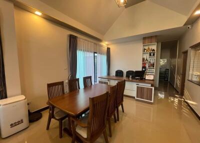 Spacious dining room with modern furniture and adjacent kitchen area