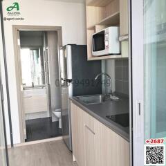 Compact modern kitchen with stainless steel sink, appliances and bathroom entrance