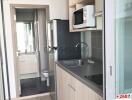 Compact modern kitchen with stainless steel sink, appliances and bathroom entrance