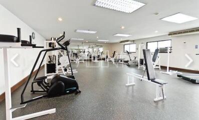 Spacious gym with modern equipment and large windows in a residential building