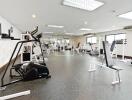 Spacious gym with modern equipment and large windows in a residential building