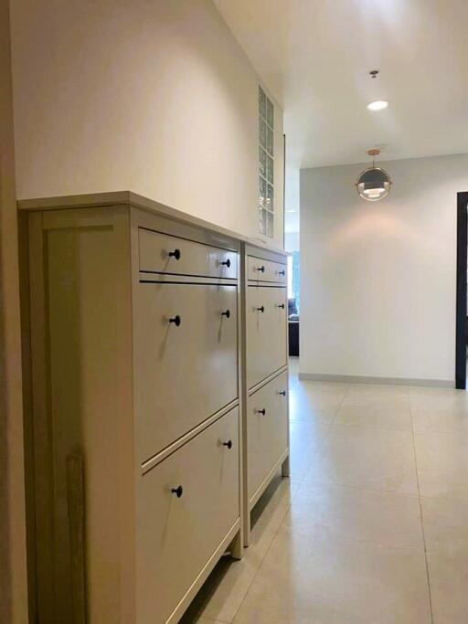 Spacious hallway with a white storage cabinet and tiled flooring