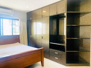 Spacious bedroom with built-in wardrobe and wooden bed