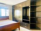 Spacious bedroom with built-in wardrobe and wooden bed