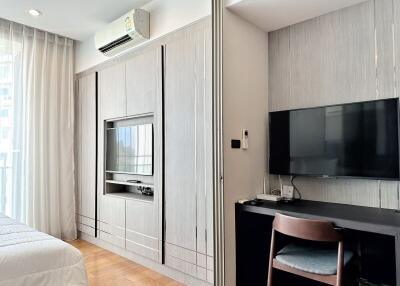 Modern bedroom with built-in wardrobe and TV