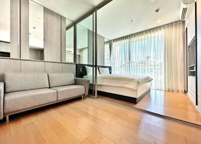 Modern bedroom with hardwood floors featuring an en-suite bathroom and floor-to-ceiling windows