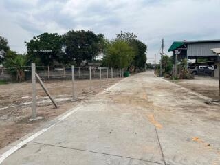 Empty outdoor space with concrete ground and fence posts