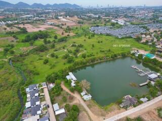 Aerial view of residential area with pond and greenery