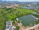 Aerial view of residential area with pond and greenery