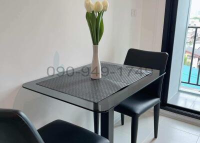 Modern dining area with glass table and two chairs