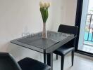 Modern dining area with glass table and two chairs