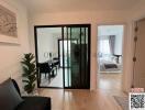 Modern living room with adjacent bedroom view through sliding doors