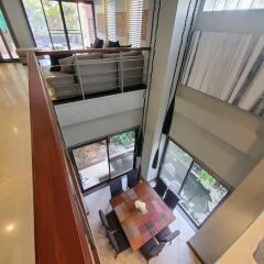 Spacious and well-lit living room area with high ceiling and modern design