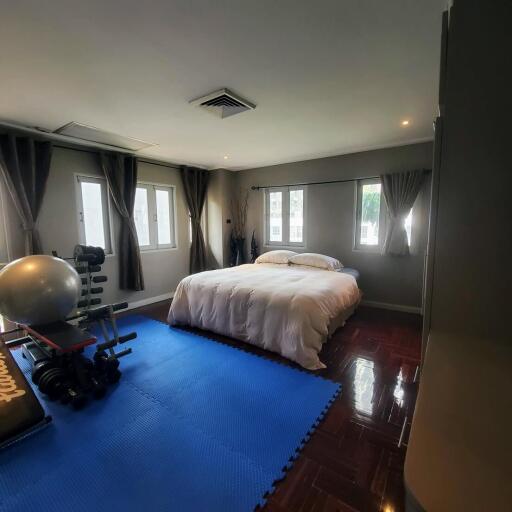 Spacious bedroom with exercise area and glossy hardwood floors