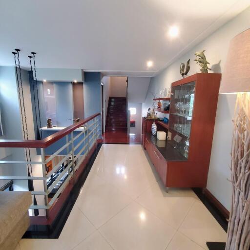 Spacious upper floor interior with glossy tiled flooring and modern staircase