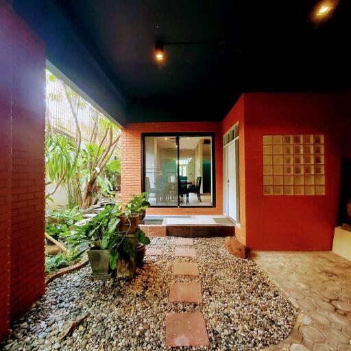 Cozy patio area with red accent walls and natural stone path