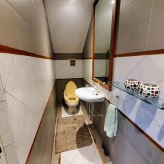 Compact bathroom with modern fixtures and tiled walls