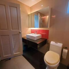 Modern bathroom with red accent tiles and a glass shower