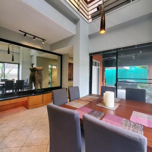 Spacious dining room with large table, modern chairs, and direct view into the backyard